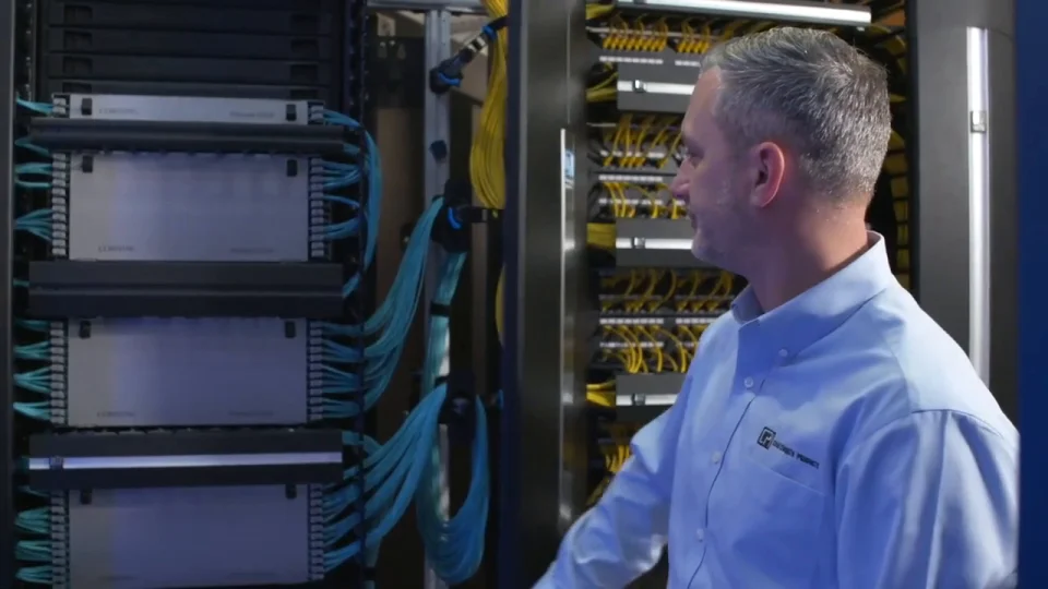 Professional technician in hard hat installing access control card reader at commercial facility